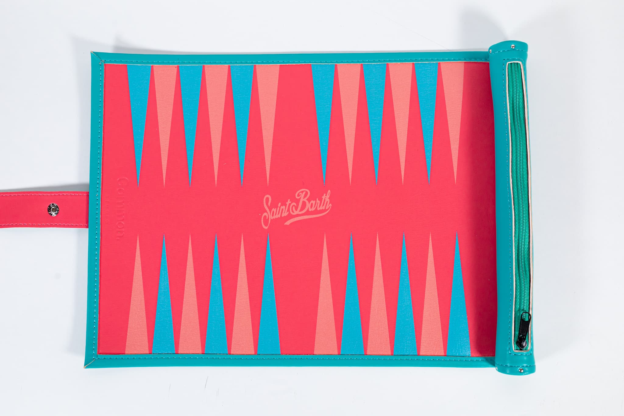 Overhead view of an open coral and turquoise Saint Barth backgammon board