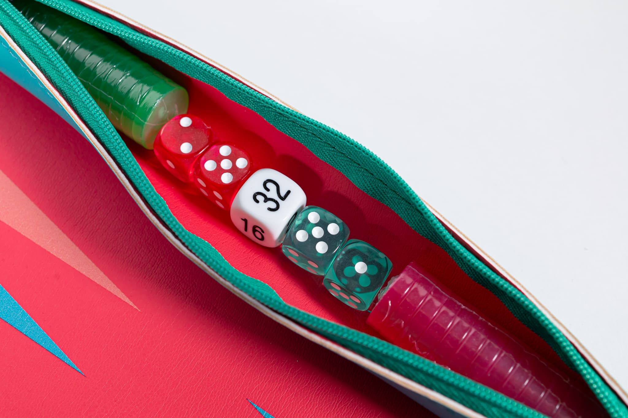 Colorful backgammon dice and pieces arranged on a coral leather board